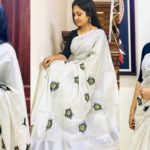 Gayatri Arun in a beautiful white sari, taking pictures on social media